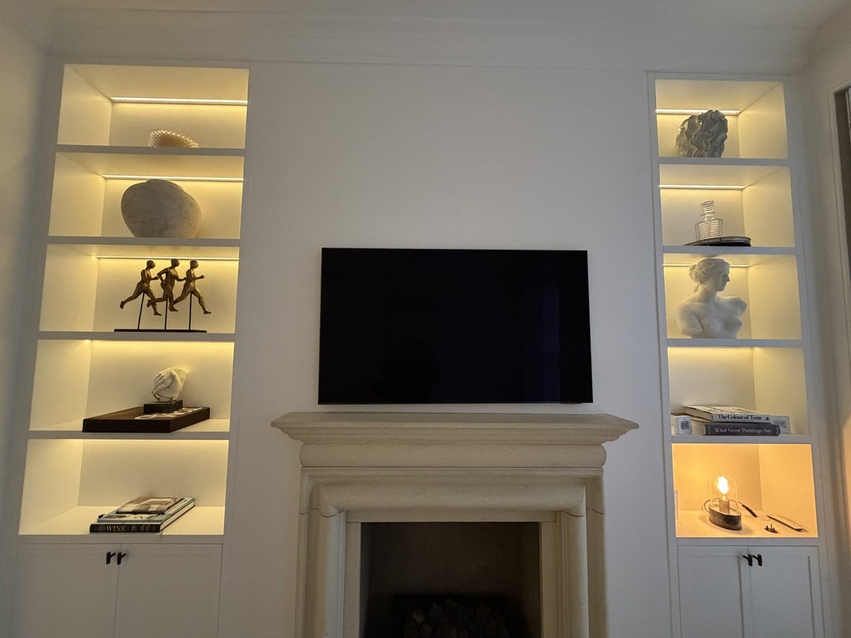 Alcove shelving either side of a fireplace lit with budget LED strip